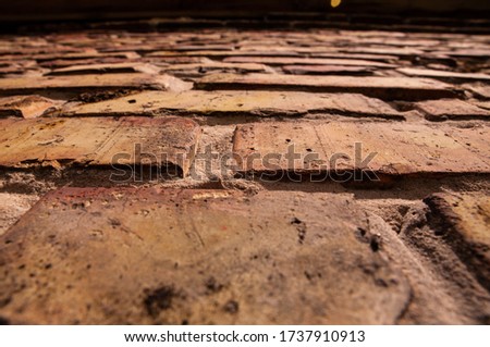 Old brick texture. Fully filled image of a building facade with damaged stucco. Background of an old brick wall