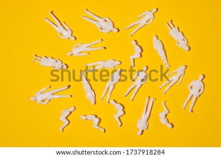 toy figures of people on a yellow background