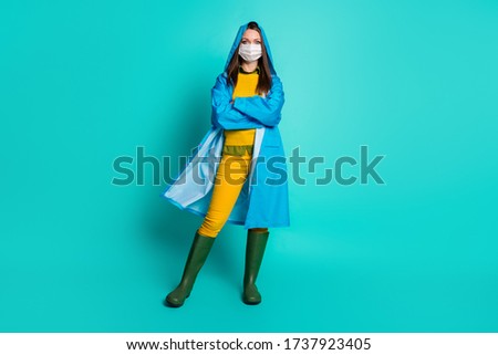 Full length photo of pretty lady rainy weather use medical infection flu mask quarantine distancing arms crossed wear raincoat sweater pants gumboots isolated teal color background