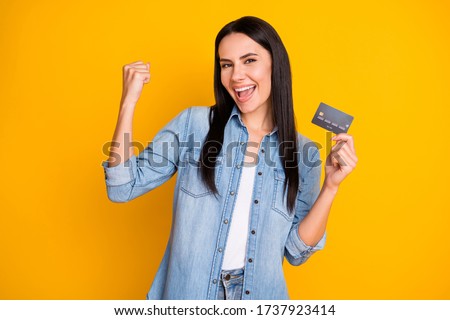 Close-up portrait of nice attractive lovely pretty cute cheerful cheery girl holding in hand cell plastic card new solution novelty advert isolated bright vivid shine vibrant yellow color background