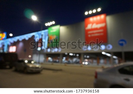 Blurred background. Shopping center building with bright illumination.
