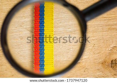 colombia flag with magnifying glass and wooden background research explore