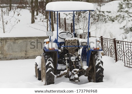 Tractor with an open cockpit covered with snow.