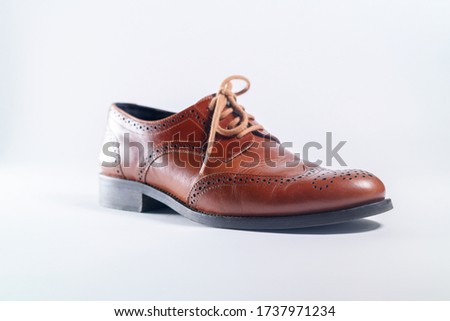 Classic brown leather one shoes on white background. Concept of elegant hand made fashionable genuine product.