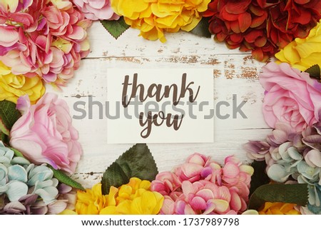 Thank you Card with colorful flowers border frame on wooden background