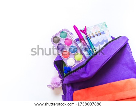 Backpack with school supplies and books for study. Bright color rainbow. Back to school concept. Flat lay, top view