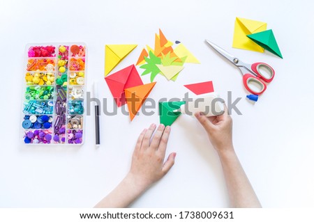 Bookmark for a child book to school. Origami paper craft with children's hands. Summer fruit tropics.