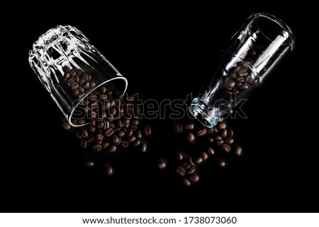 Flat lay coffee bean in clear glass bottle and glass cup on black for website advertisement or banner view above