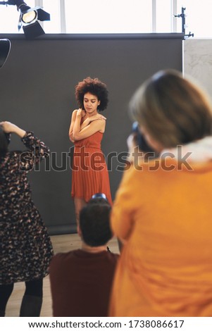 Group of photography attendees photographing model. Photography class in studio.