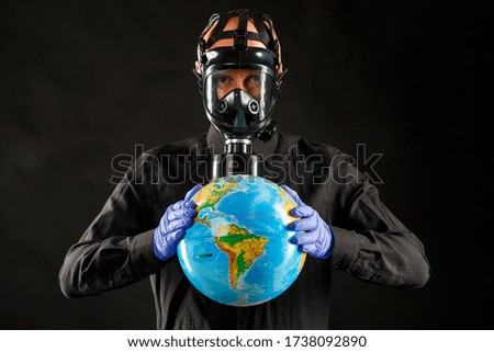 Earth in the hands of a man in gloves. The concept of disinfection. Great danger to the world Covid-19.
