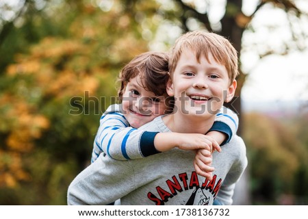 Two happy boys, happy brothers who are smiling happily together. Brothers play outdoors in summer, best friends. Little brother with brother on his back. Two brothers in the woods. Fraternal relations Royalty-Free Stock Photo #1738136732