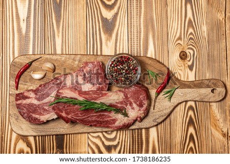 Raw beef steak with garlic, paper and rasemary