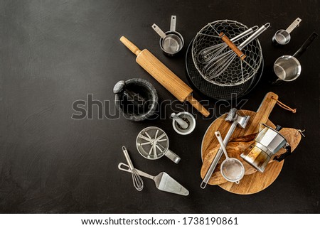Kitchen utensils (cooking tools) on black chalkboard background. Kitchenware collection captured from above (top view, flat lay). Layout with free copy (text) space.  Royalty-Free Stock Photo #1738190861