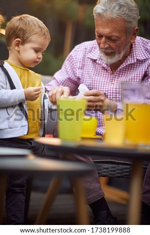 Cute grandson have fun with their grandfather outdoor at home.