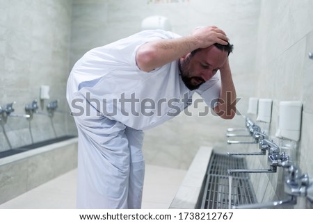 Muslim man taking ablution for prayer. Islamic Religious Rite Ceremony Of Ablution. Young Muslim man perform ablution (wudhu) before prayer. Royalty-Free Stock Photo #1738212767