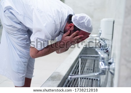 Muslim man taking ablution for prayer. Islamic Religious Rite Ceremony Of Ablution. Young Muslim man perform ablution (wudhu) before prayer. Royalty-Free Stock Photo #1738212818