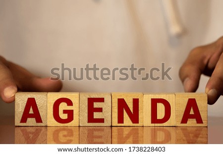Agenda Concept Wood Blocks with old wooden background.