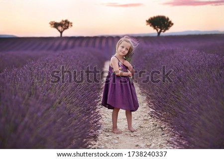 
Portrait of a little girl in a lavender field.
Image with selective focus, noise effects and toning. Focus on the girl.