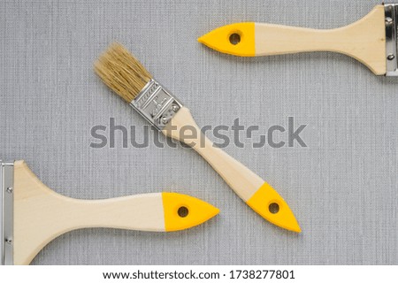 Three clean different sized paint brushes Isolated on grey background. Repair and home renovation concept. Copy space. No people. Close up