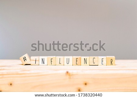 Wooden cubes with a hashtag and the word Influencer, social media concept and background close-up