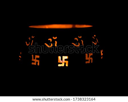 A pot with burning candle inside and popping out symbols from the pot 