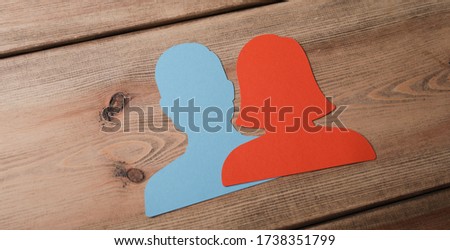 A panoramic shot of blue and red male and female icons on a wooden background