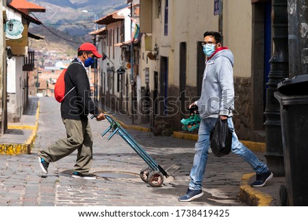 People in respiratory masks are going to buy food in empty street during coronavirus pandemic in Latin South America. Epidemic of covid-19 Royalty-Free Stock Photo #1738419425