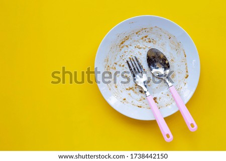 Dirty dish on yellow background. Top view