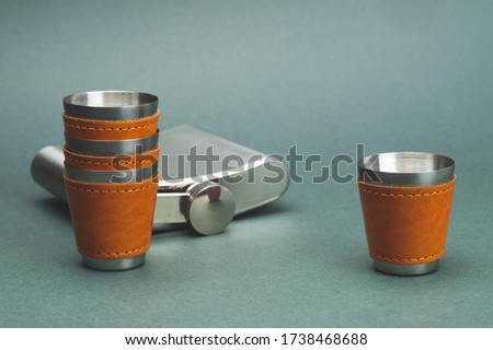 Metallic shot glasses and flask. travel shot glass for alcohol with leather casing over the stainless steel. personal accessory set