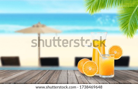 Summer Vacation Concept : Welcome drink orange juice punch put on wooden table with blurry blue water and seascape view in background.