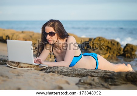 Woman with laptop working on the beach. Place for text.
