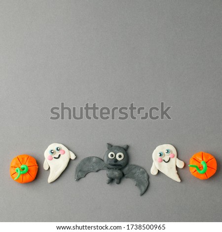 Halloween pumpkins, ghosts, bat and spider for seasonal holiday Halloween days festival create from color clay on gray background, DIY idea for kids, copy space
