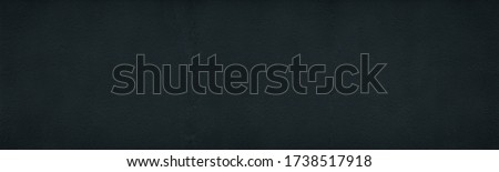 Black rough plastered concrete wall wide texture. Fine textured painted cement plaster surface. Dark large abstract background