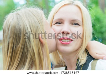 Happy mother. Mom kisses her daughter. Toned.