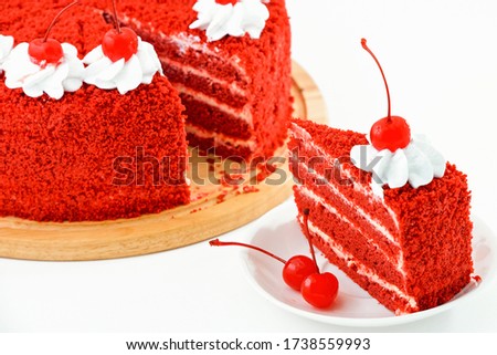 round red velvet cake on a wooden plate decorated with canned cherries and whipped cream, slice of cake on a white saucer, a beautiful cake on a light background, close-up of a pastry homework edition