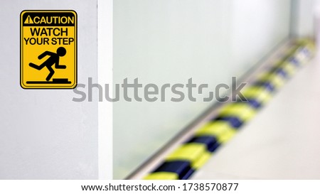 Caution watch your step graphic design with warning hazard construction stripes sign symbol blurred background isolated in concrete floor, safety first in laboratory walk way to watch out your step.