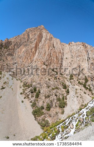 The beautiful mountain trekking road with clear blue sky and rocky hills in Fann mountains in Tajikistan
