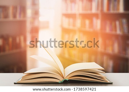 Open hardcover book on table in library