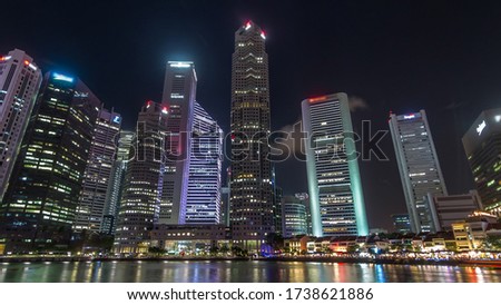 Singapore quay with tall skyscrapers in the central business district and small restaurants on Boat Quay night view . Towers reflected in water Royalty-Free Stock Photo #1738621886