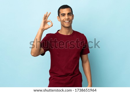 African American man over isolated background showing ok sign with fingers