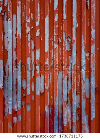 An old, weathered metal wall with red paint.