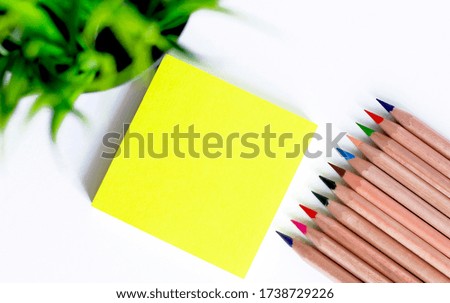 Colored pencils on a block yellow stickers