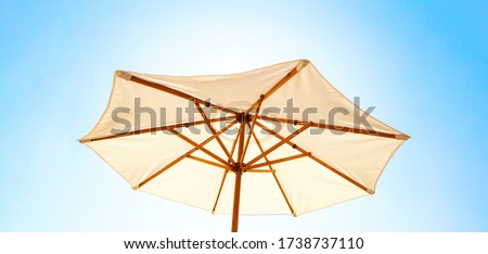 White sun umbrella for shade low angle view against clear blue morning sky. Concept of concept of summer vacation or weekend staycation, banner, center composition. Royalty-Free Stock Photo #1738737110