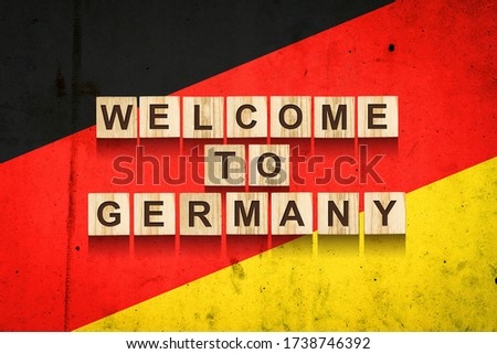 Welcome to Germany. The inscription on wooden blocks on the background of the flag of Germany.