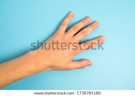 Close up of man's hand isolated on blue background