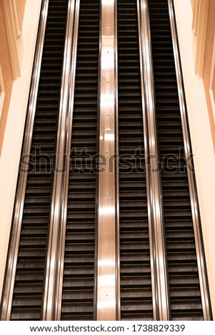 Up and down escalators inside unknown hotel lobby