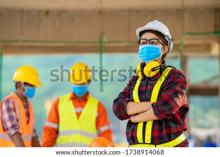 Builders wearing safety helmet with blueprint at construction,Concept of residential building under construction.