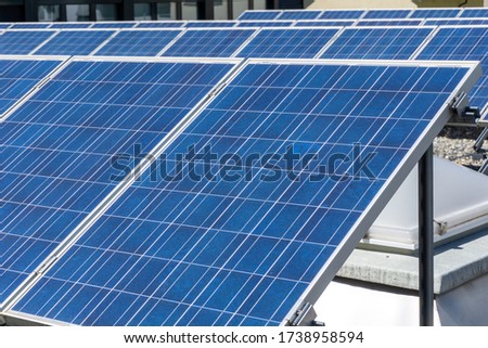 A close up view of a row of modern solar panels on a flat rooftop