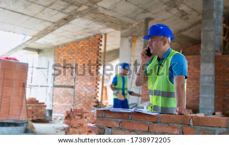 The construction site manager talking on the phone image.Constructing site picture.