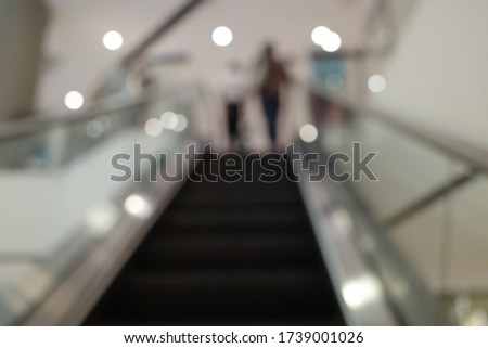 People in motion in escalators at the modern shopping mall.